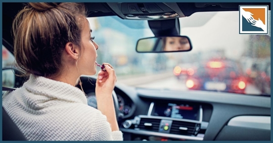 Woman applying lipstick while driving